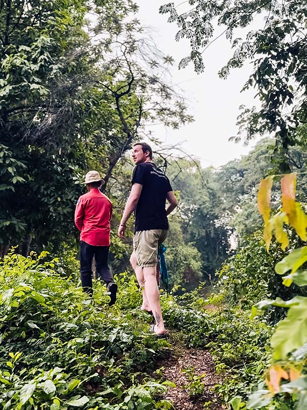 Matt and a local tour guide hiking through the jungle to find hidden temples in Cambodia