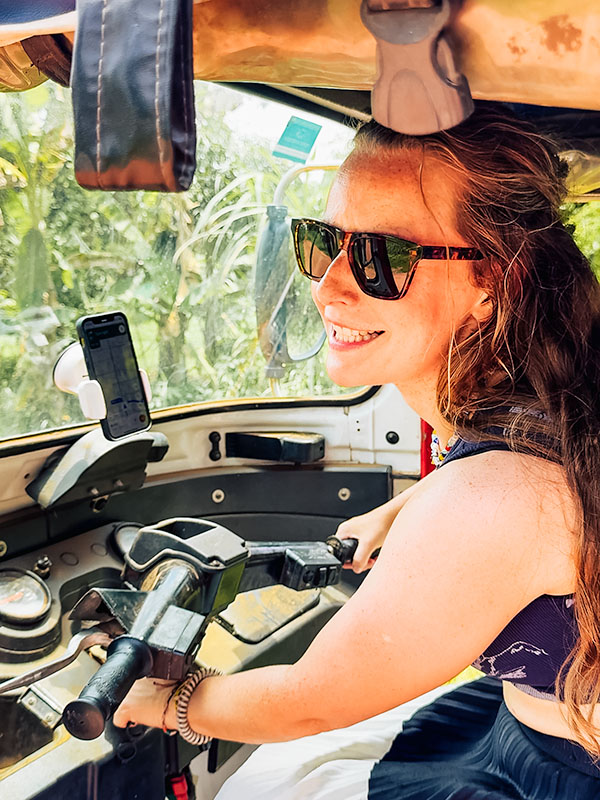 Katie smiling, ready to drive off having chosen to rent a tuktuk in Cambodia