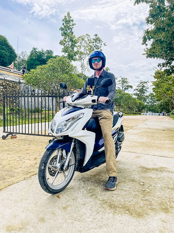 Matt sitting on a scooter wearing a helmet