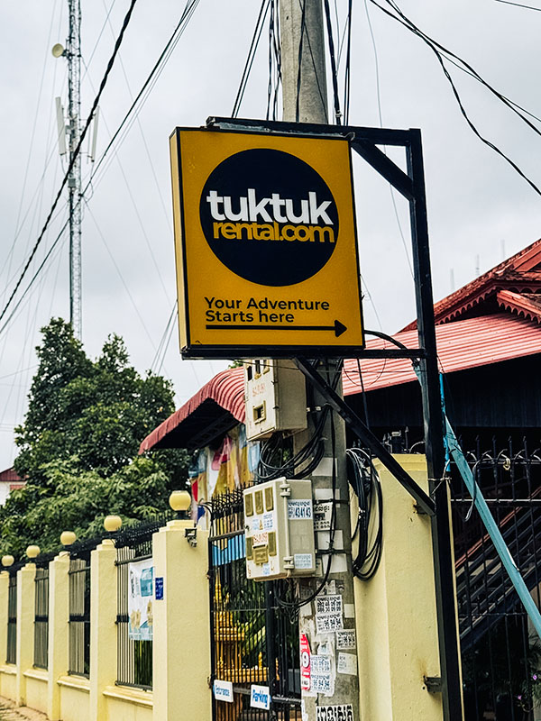 Sign in Siem Reap saying "tuktukrental.com Your Adventure Starts here"