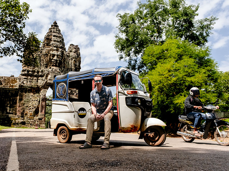 A tuktuk and scooter in front of Tonle Om (South Gate) at Angkor Wat, Siem Reap